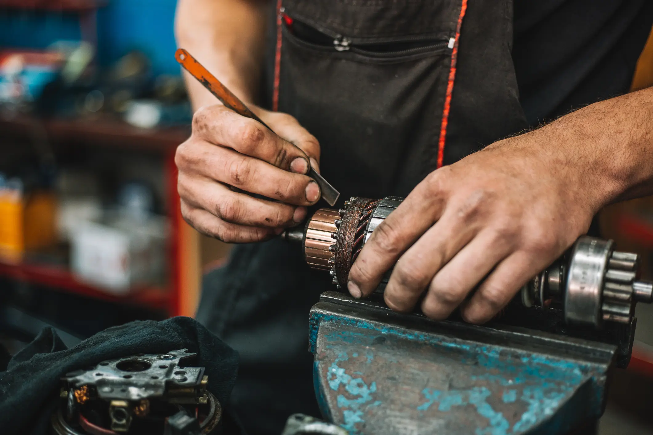 Mechanic repairing motor part in workshop.