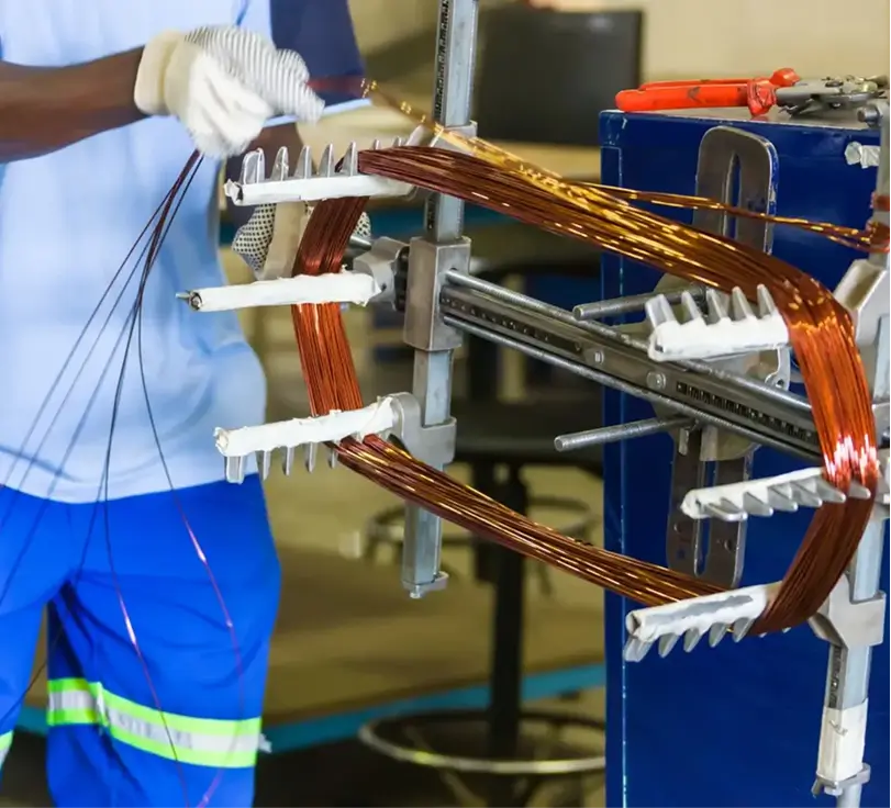 Person working with copper wire machine.