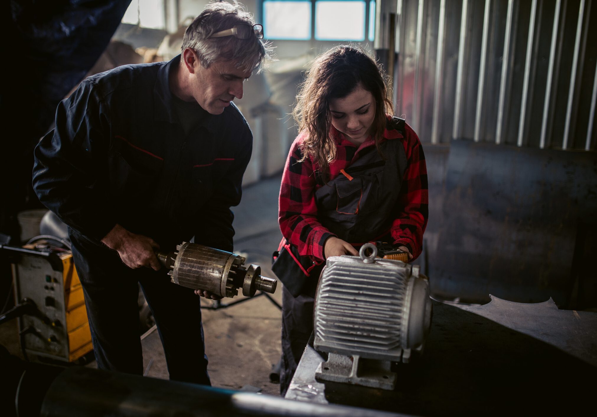 Two people working on industrial machinery.